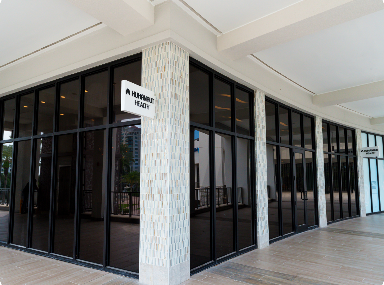 Exterior of a Humanaut Health clinic — a glass-walled building with brand signage